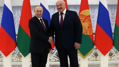 EPA Russian President Vladimir Putin and Belarusian President Alexander Lukashenko shake hands before their meeting at the Palace of Independence in Minsk, Belarus