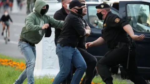 EPA Police officers wearing protective face masks detain a protester during a rally in Minsk, Belarus