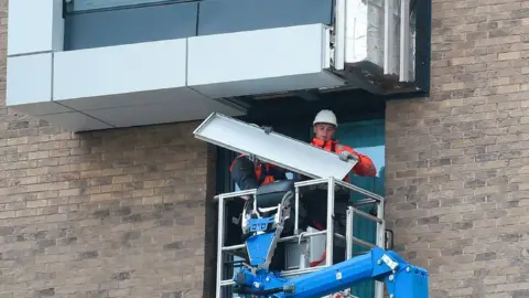 AFP Workmen removing external cladding from a building in Manchester after fire safety tests in the wake of the Grenfell Tower tragedy