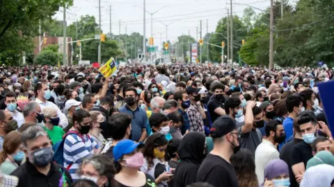 Getty Images A crowd gathers at a London, Ontario vigil for the Afzaal-Salman family