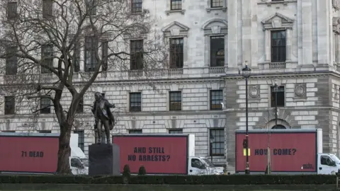 Jeff Moore/Justice4Grenfell The three red and black billboards, which say: "71 dead. And still no arrests. How come?"