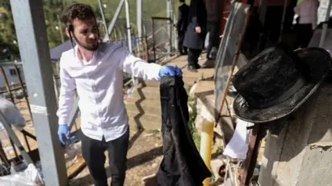 A man holding up belongings near the site of the accident