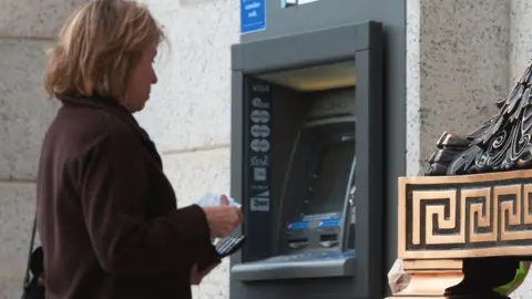 Getty Images A woman at an ATM in the US