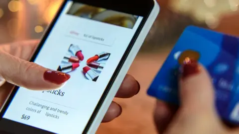 Getty Images Woman buying lipstick on her mobile