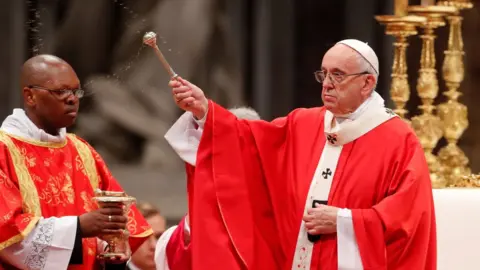 Reuters Pope Francis sprinkles holy water during a Mass of Pentecost at Saint Peter"s Basilica at the Vatican, May 20, 2018.
