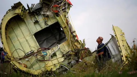 Reuters An investigator inspects the wreckage of flight MH17. File photo