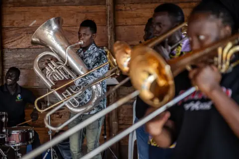 LUIS TATO/AFP Members of a senior brass band from Brass for Africa rehearse ahead of a performance in Kampala.