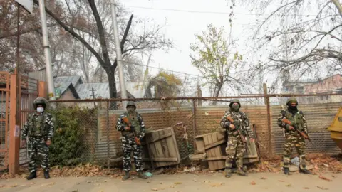 Getty Images Indian forces stand alert outside a voting booth in Srinagar on 01 December 2020.