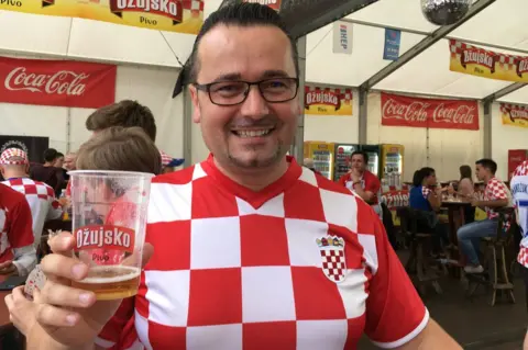 A picture of Croatia fan Daniel holding a pint of beer and smiling