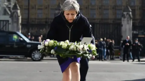 EPA Theresa May has laid a floral tribute outside parliament