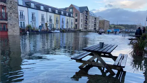 Flooding from a river and a picnic bench in floodwater