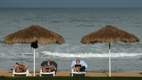 AFP/Getty Tourists relaxing on a beach in Sri Lanka