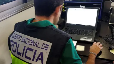 Spanish national police Police officer on laptop