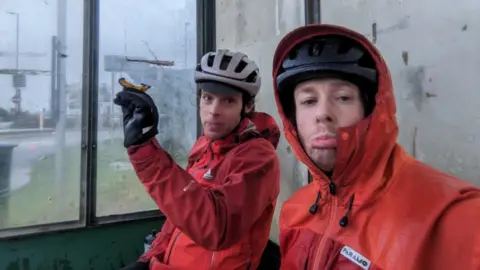 Ben Cannell Cyclists sitting down in a shelter