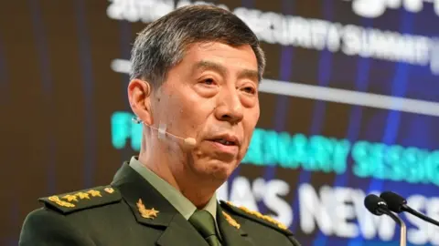 Getty Images China's Minister of National Defence Li Shangfu delivers a speech during the 20th Shangri-La Dialogue summit in Singapore on June 4, 2023.