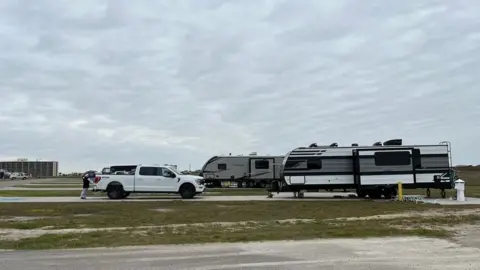 Annick Ruedi Annick Ruedi's RV trailer parked near an overcast Mustang Island beach.