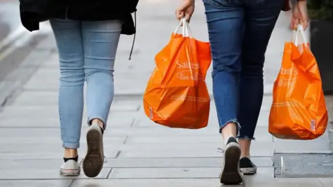 Getty Images Shoppers carrying Sainsbury's bag