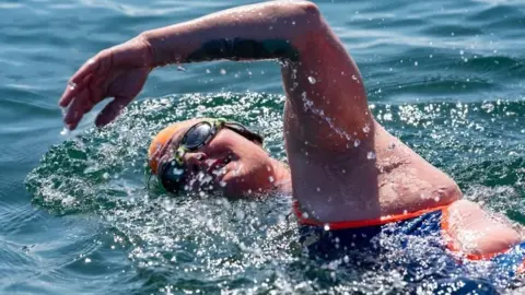 Hollister Gill swims in the sea