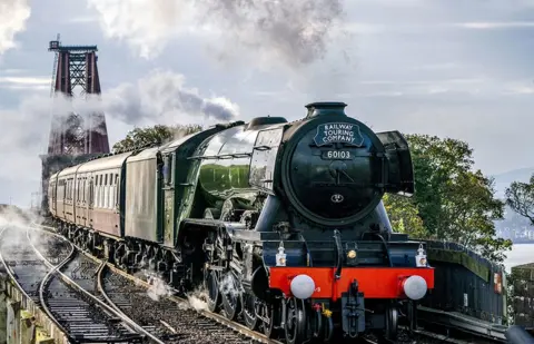 Jane Barlow / PA Media The Flying Scotsman passes over the Forth Bridge near North Queensferry, Fife, in Scotland