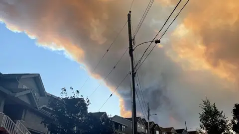 Smoke from the Tantallon wildfire rises over houses in nearby Bedford, Nova Scotia, Canada