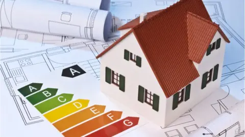 Getty Images A model of a house and an energy performance certificate on some floorplans