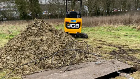 Nicola Player Mound of earth and a digger at Easthill