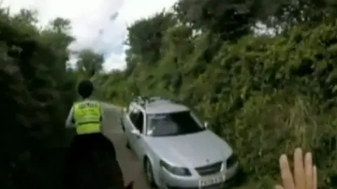 A car being driven close to a horse and its rider on a country lane