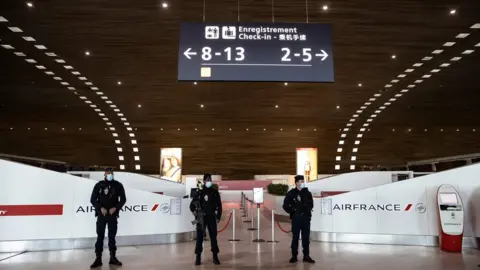 AFP / Getty Images French police officers in Charles de Gaulle international airport in France during the coronavirus pandemic