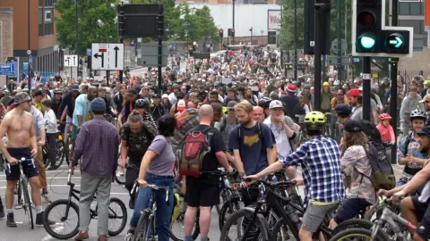 BBC People waiting on their bikes