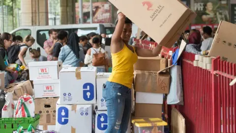 PA Volunteers organise boxes of donations following near Grenfell Tower in west London