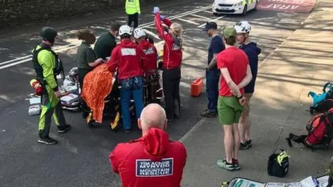 Ogwen Valley Mountain Rescue rescuers treating man on road