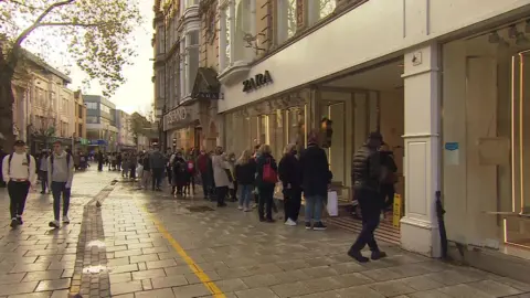 BBC People queuing outside a shop in Cardiff