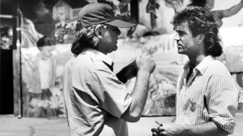 Getty Images Donner talks with Mel Gibson on set of Lethal Weapon