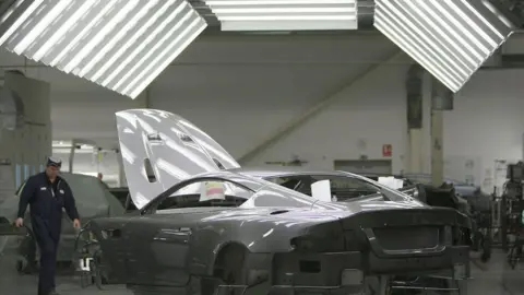 Getty Images A man works on an Aston Martin