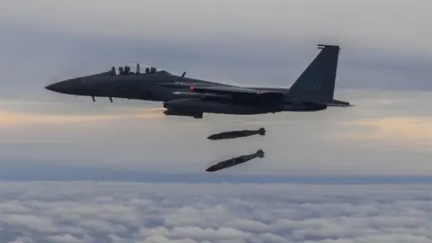 EPA A handout photo made available by the South Korean Defence Ministry shows a South Korean F-15K fighter dropping two JADAM precision bombs during a drill in the sky over South Korea, 04 October 2022.