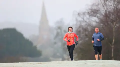 Stuart Martin / Alamy Live News Runners on a cold and frosty morning near Lyndhurst in the New Forest