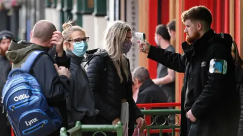 Getty Images People being temperature scanned outside bar in Liverpool