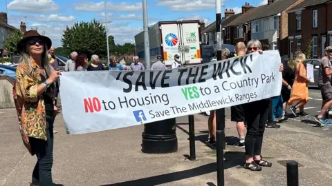 Richard Smith Protesters holding a "Save the Wick" banner during a protest in Colchester
