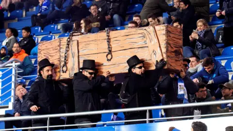 Alaves supporters dressed in black carrying a mock coffin in protest during their game against Levante