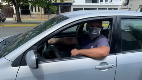 Manuel's son waits in a queue for petrol in Valencia