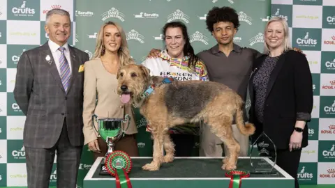 BeatMedia/The Kennel Club Diesel, his owner Claire, and judges at Crufts