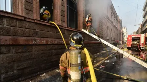 AFP Firefighters work to put out a fire at Honduran Telecommunications company HONDUTEL, set on fire during clashes following a protest of students of the National Autonomous University of Honduras (UNAH) and elementary school teachers against the approval of education and healthcare bills in the Honduran Congress in Tegucigalpa on April 29, 2019.