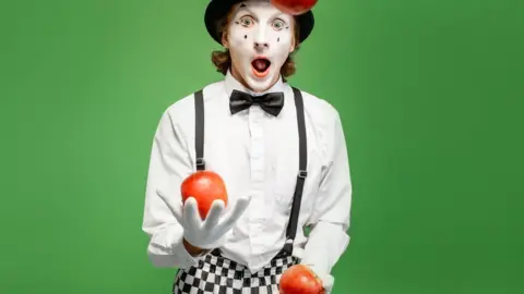Getty Images Mime juggling apples