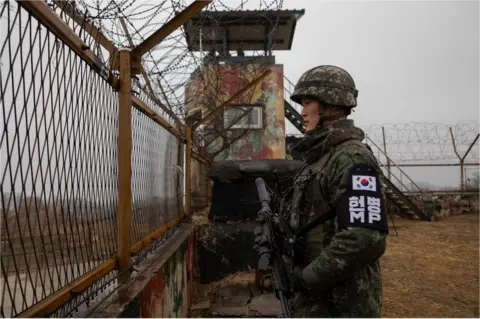 Getty Images A South Korean solider keeps watch over the DMZ