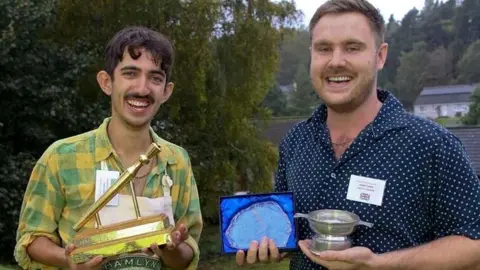 Adam Kiani holding his golden spurtle award and specialty winner, Bobby Fisher