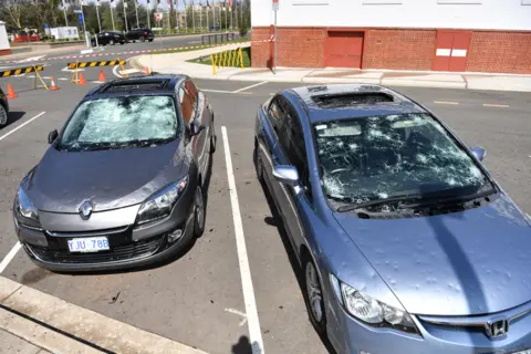 EPA Damaged cars are seen parked outside Old Parliament House after a hail storm hit Canberra