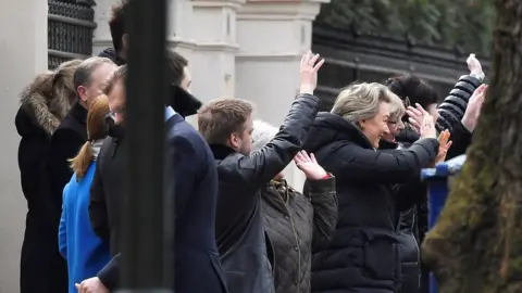 Reuters Embassy staff wave as colleagues and children board buses outside Russia"s Embassy in London,