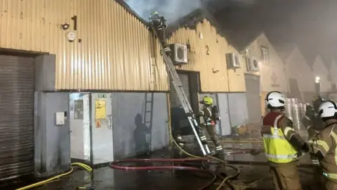 Firemen fighting a fire in the industrial units