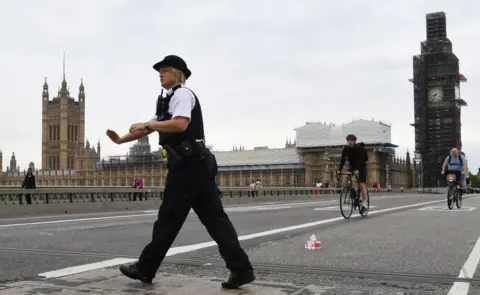 PA Police on Westminster Bridge, central London, after a car crashed into security barriers outside the Houses of Parliament.