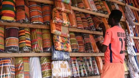 AFP A man in a shop selling traditional African fabric.